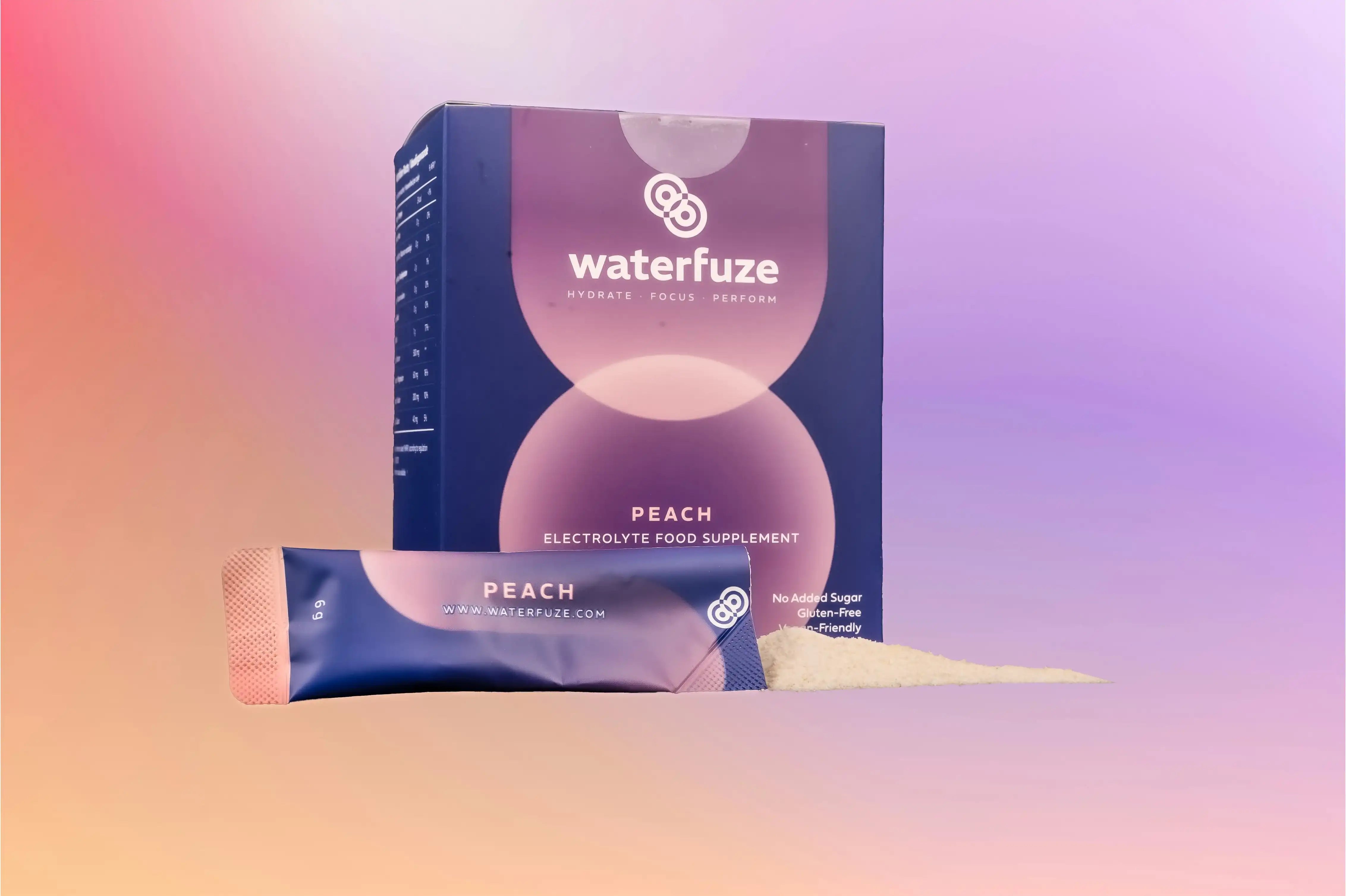Waterfuze elektrolyten supplement perziksmaak in doos en sachet met poeder op pastel achtergrond